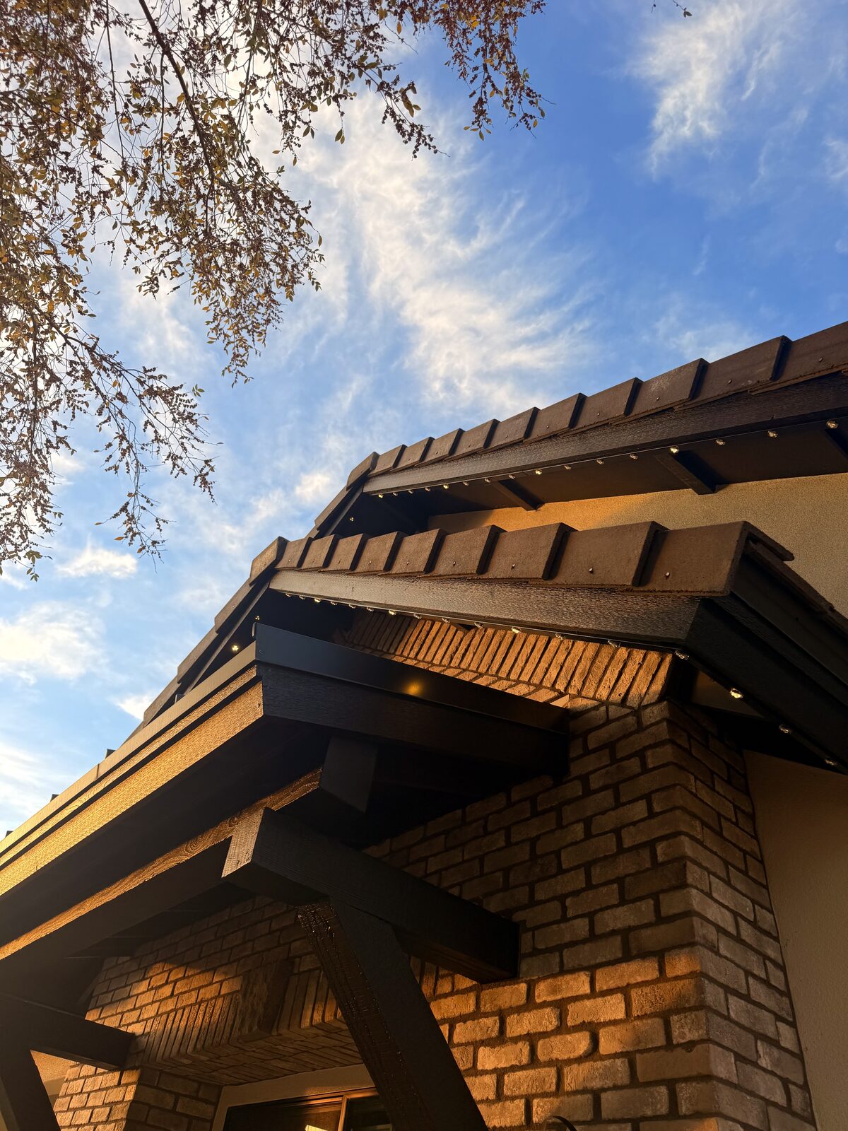 Home rooflines lit with multicolor permanent lighting during blue hour